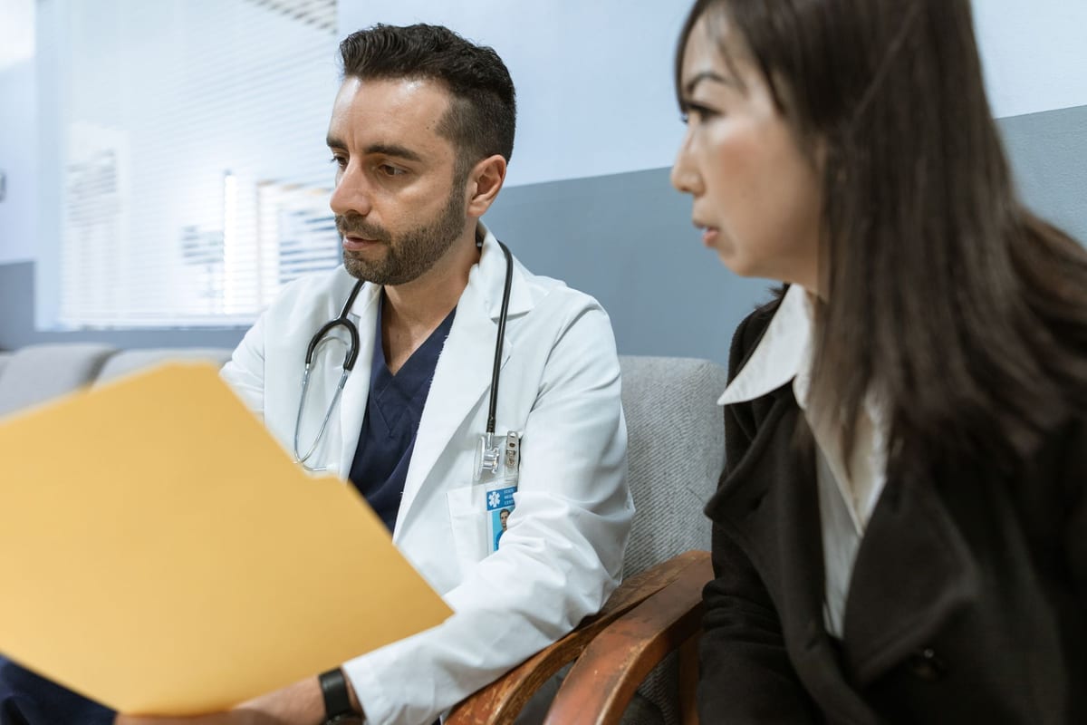 A doctor going over a patient's file with her during an appointment
