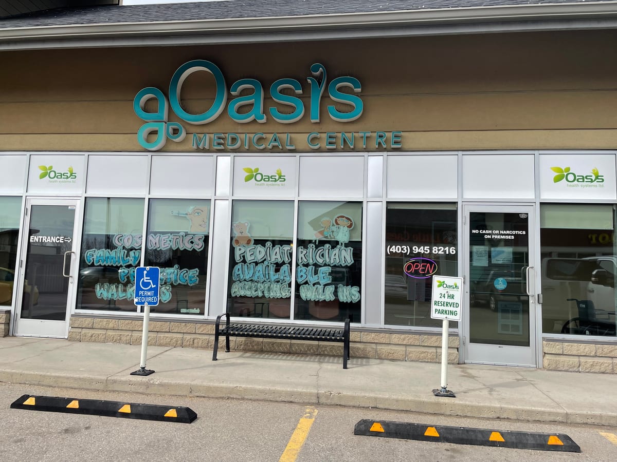 The entrance of the Oasis Medical Centre at Stonegate, with walk-in hours lettered on the windows